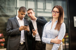 two coworkers gossiping about a female employee behind her back