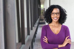 a woman wearing a purple sweater with her arms crossed