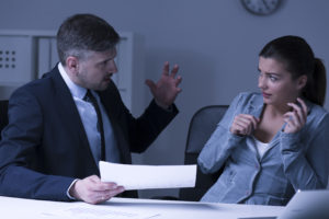 angry boss yelling at an employee as the employee cowers in fear