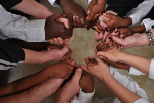 hands of white and black people held together in a circle