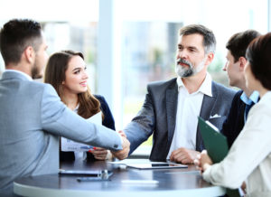 a group of business professionals shaking hands in an office