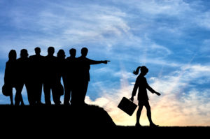 silhouettes of office workers pointing for a woman to leave their group