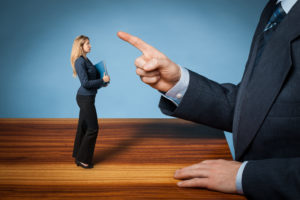 a small woman being pointed at by a larger-than-life hand