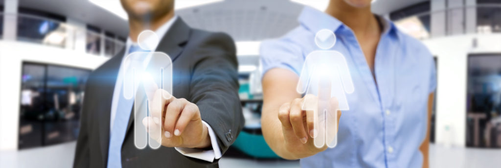 a man and a woman in an office touching a glass wall with an outline of male and female employees on it