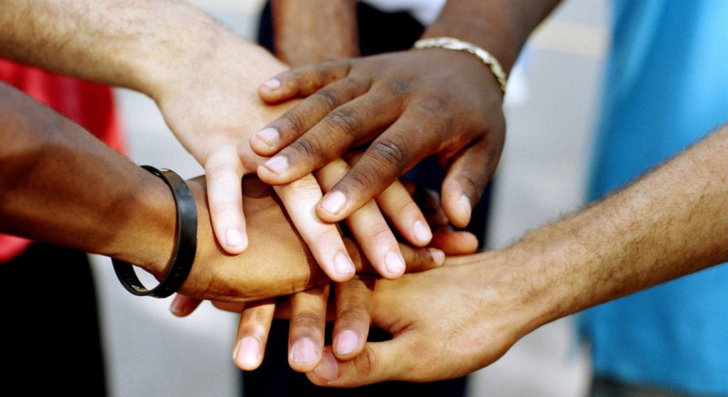 a group of people putting their hands together