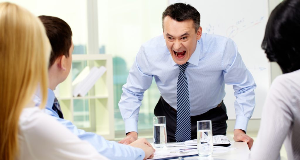 an angry boss yelling at employees who will require assitance from an employment attorney