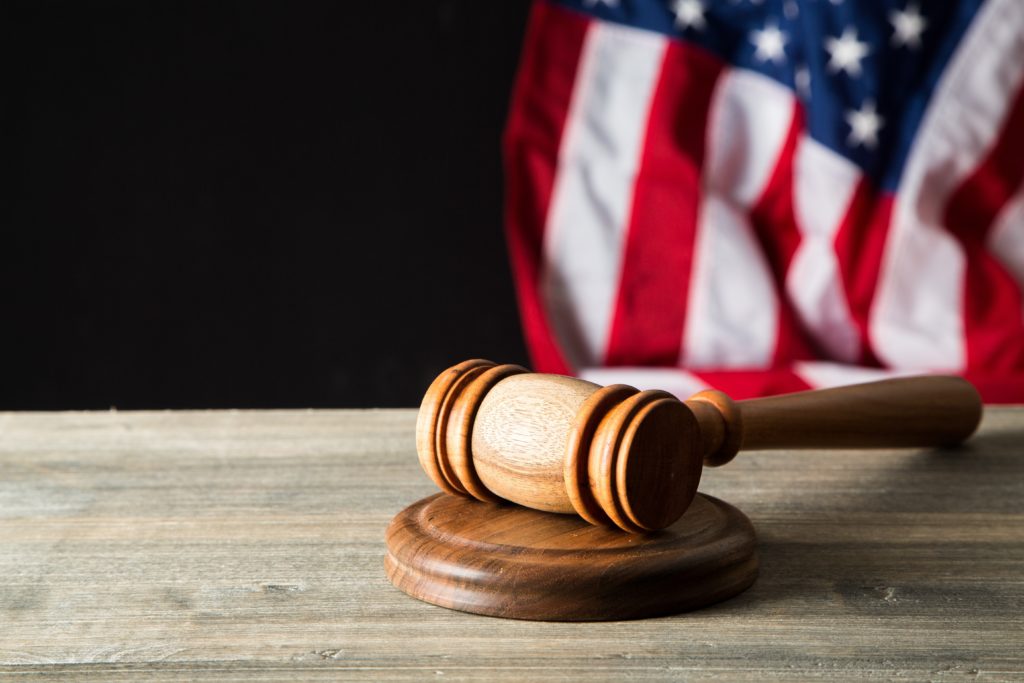 gavel on a wooden table with the American flag in the background