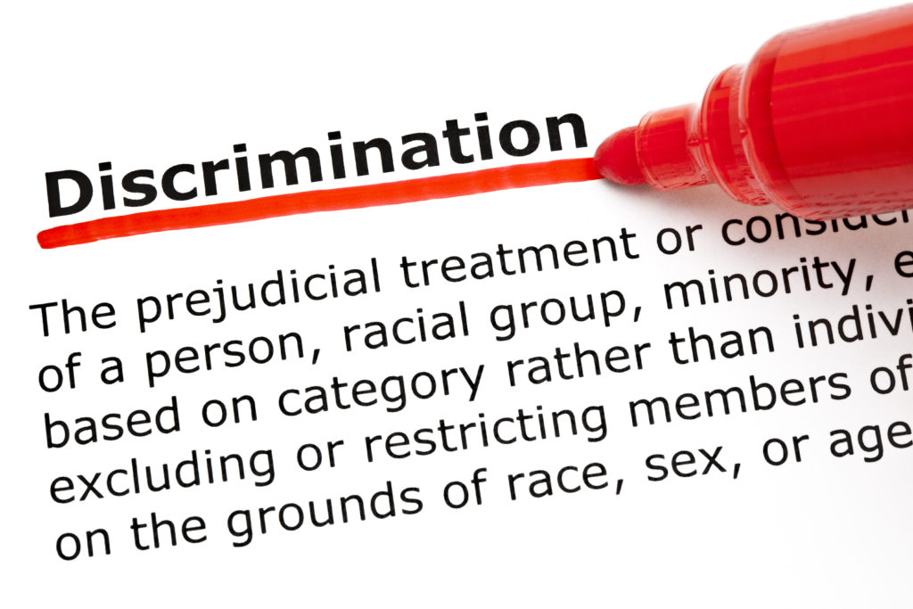 Definition of the word Discrimination underlined with red marker on white paper.