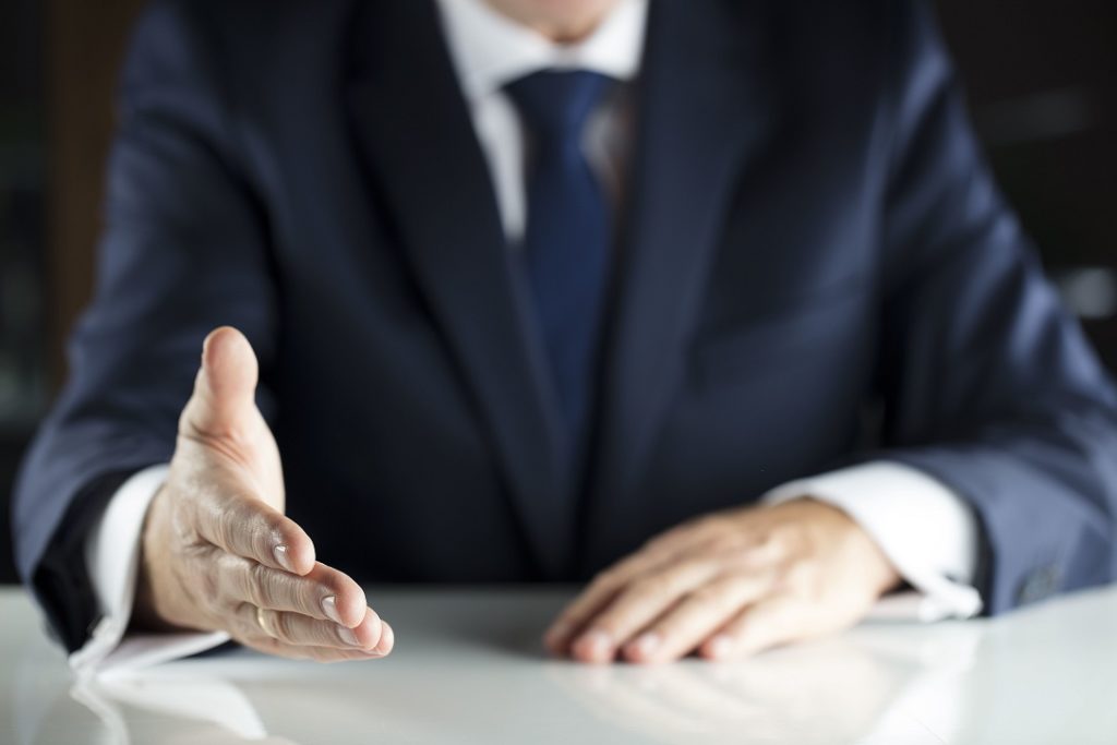 employment attorney from neck down reaching out to shake hand